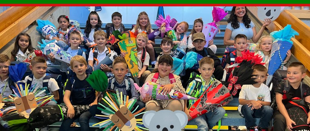 Schulkinder auf der Treppe sitzend bei der Einschulung 2025/2026 Alternativer Text Einschulung